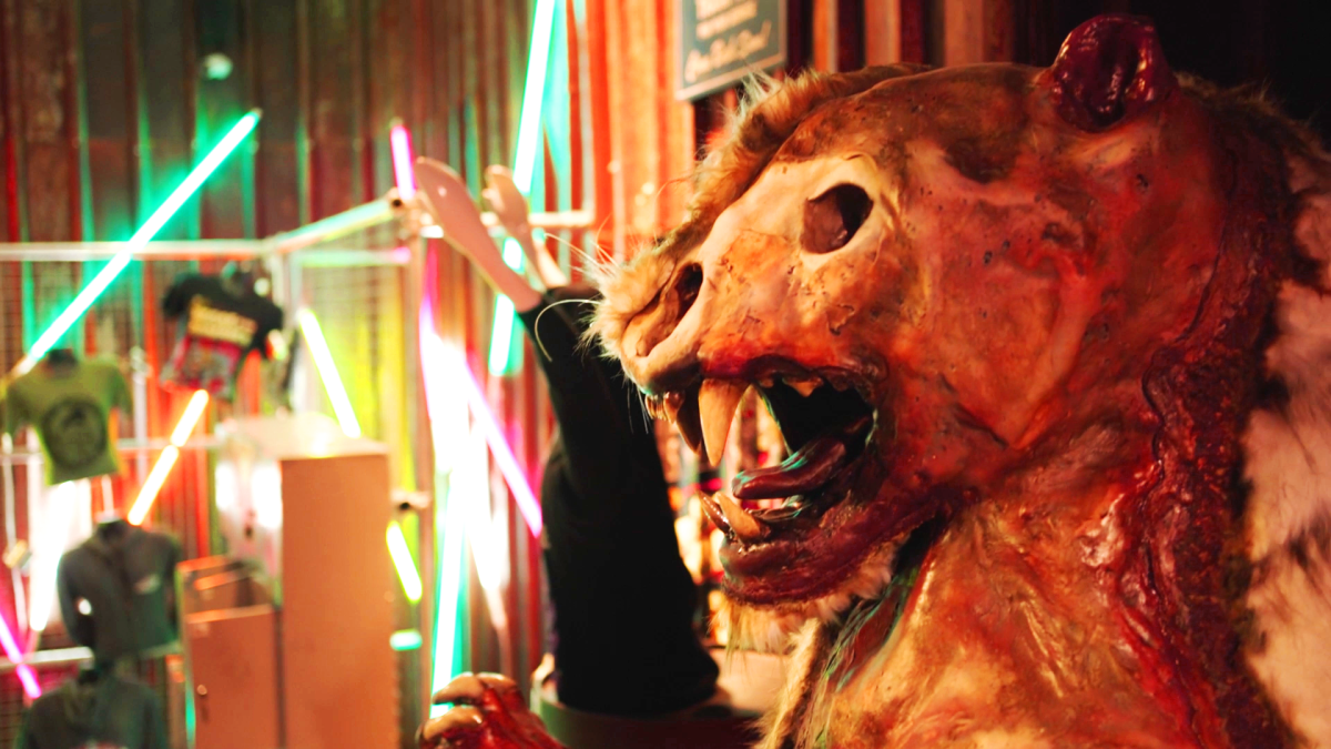 A statue of a lion skeleton in a neon lit room